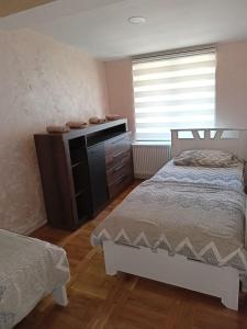 1 dormitorio con 1 cama, vestidor y ventana en Tina en Užice