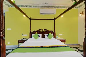 a bedroom with a large bed with a wooden canopy at Hotel Karohi Villa in Udaipur