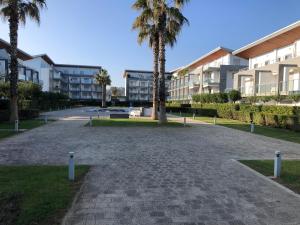 un parco di fronte a un edificio con palme di Le Dune per 4 - Appartamento con piscina a Silvi Paese