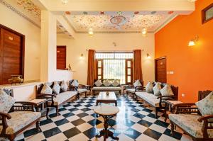 a waiting room with couches and tables in a building at Hotel Karohi Villa in Udaipur