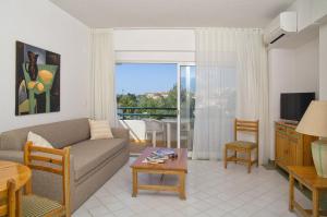 a living room with a couch and a tv and a table at Ourabay Hotel Apartamento - Art & Holidays in Albufeira