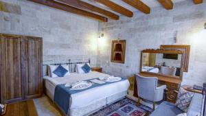 1 dormitorio con cama, escritorio y lavamanos en Elegance Cave Suites & Restaurant, en Göreme