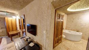 ein Badezimmer mit einer Badewanne, einem WC und einem Waschbecken in der Unterkunft Elegance Cave Suites & Restaurant in Goreme