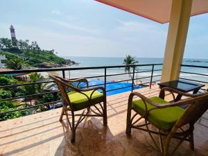 2 stoelen en een tafel op een balkon met uitzicht op de oceaan bij Karma Beach Resort in Kovalam