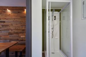 y baño con ducha y pared de madera. en Ferienanlage Kirchzarten, en Kirchzarten