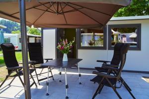 einen Tisch und Stühle unter einem Sonnenschirm auf einer Terrasse in der Unterkunft Ferienanlage Kirchzarten in Kirchzarten