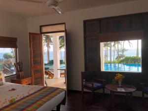 a bedroom with a bed and a view of the ocean at Turtle Bay Boutique Hotel in Tangalle