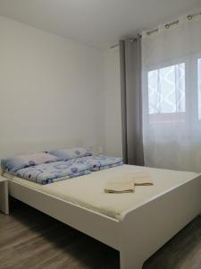 a white bed in a room with a window at Noclegi u Eugenii in Licheń Stary