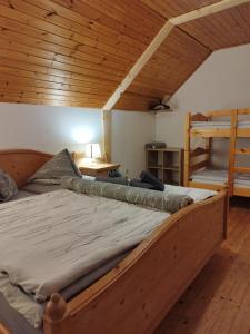 ein großes Bett in einem Zimmer mit Holzdecke in der Unterkunft Grundnerhof in Arriach