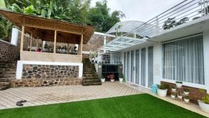 uma casa com um pátio com relvado em Teras Luhur Villa & Cafe dengan Pemandangan Gunung dan Pesawahan 