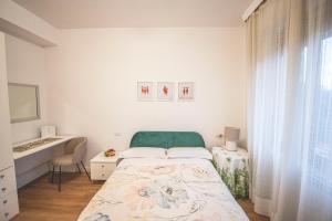 a white bedroom with a bed and a desk at B&B Il Girasole in Corciano