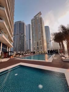 a swimming pool in a city with tall buildings at Stylish 2 bdr in Dubai Marina & hotels beach access available in Dubai