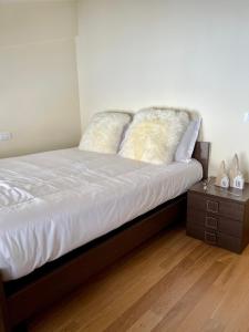 een bed met 2 kussens en een nachtkastje bij Casa Montagne in Roccaraso