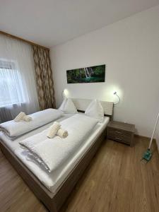 a bedroom with two beds with white sheets at Pension Alpina in Roppen