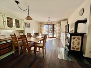 a kitchen and dining room with a table and a wood stove at Sweet Alpen Home in Garmisch-Partenkirchen