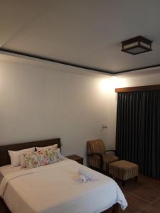 een hotelkamer met een bed en een stoel bij The luxe villas lombok in Kuta Lombok