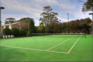 a tennis court with a net on top of it at Coconuts - 3 bedroom 3 bathroom townhouse with tennis court in Nelson Bay