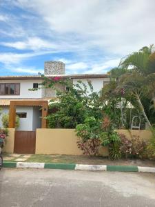 a house with a fence in front of it at CORVINA SUMMER HOUSE in Guarajuba
