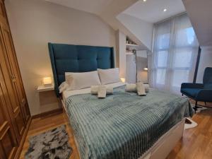 a bedroom with a large bed with a blue headboard at 614A Coqueto ático in Oviedo