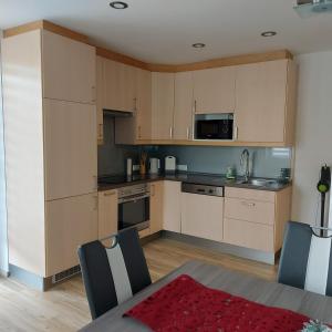 a kitchen with white cabinets and a table and chairs at Haus Mundl in Tauplitz