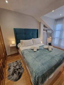 a bedroom with a large bed with a blue headboard at 614A Coqueto ático in Oviedo