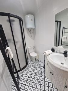 a white bathroom with a sink and a toilet at 614A Coqueto ático in Oviedo