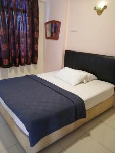 uma cama num quarto com uma cabeceira preta em Apartment at Glory Beach Resort em Porto Dickson