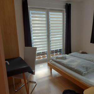 - une chambre avec un lit, une chaise et une fenêtre dans l'établissement Haus Mundl, à Tauplitz