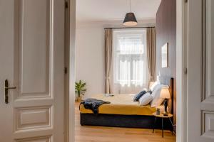 niewielka sypialnia z łóżkiem i oknem w obiekcie Kaizl Park Residence w Pradze