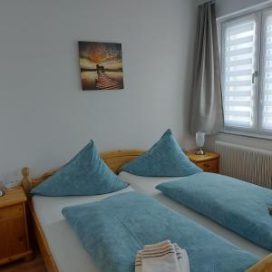 two beds with blue pillows in a bedroom at Haus Mundl in Tauplitz