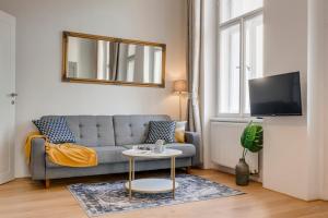 Kaizl Park Residence في براغ: غرفة معيشة مع أريكة وطاولة
