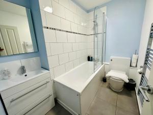 a bathroom with a toilet and a sink and a shower at X Leysdown Apartment Camden in London