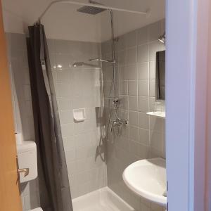 uma casa de banho com um chuveiro e um lavatório. em Haus Mundl em Tauplitz