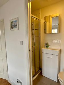 a bathroom with a sink and a toilet and a mirror at X Leysdown Apartment Camden in London