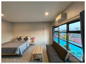 a bedroom with a bed and a couch and a pool at The One House in Nan