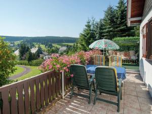a table with chairs and an umbrella on a balcony at Serene Holiday Home in Altenfeld with Private Terrace in Altenfeld