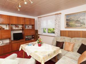 a living room with a table and a tv at Serene Holiday Home in Altenfeld with Private Terrace in Altenfeld