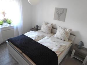 Una cama con sábanas blancas y almohadas en un dormitorio en Property in Ballenstedt, en Ballenstedt