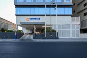 a building with a sign on the side of it at Comfort Hotel Jeddah King Road in Jeddah