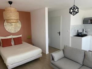 ein Wohnzimmer mit einem Bett und einem Sofa in der Unterkunft La ROSERAIE in Mont-de-Marsan