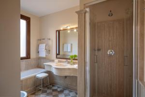 bagno con lavandino, vasca e specchio di Hotel Mozart a Roma