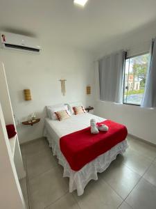 1 dormitorio blanco con 1 cama con manta roja en Taipu de Fora - Villa Ohana Flats en Taipu
