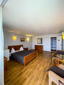 a bedroom with a bed and a wooden floor at Hotel Palma in Odesa