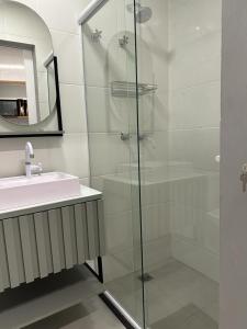 Un baño con ducha de cristal y lavabo. en Flat angra, en Angra dos Reis