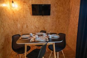 a table with chairs and plates and a television at casinha do corvo in Fátima