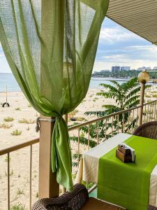 a table with a green curtain next to a beach at Hotel Palma in Odesa