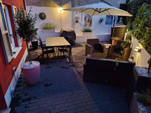 a patio with a table and chairs and an umbrella at Ferienhaus am Sauerbrunnen in Daun