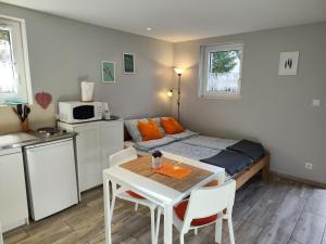 オトゥランにあるCharmant studio á Autransのベッド、テーブル、椅子が備わる小さな客室です。