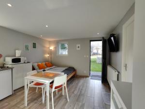 a bedroom with a bed and a table with chairs at Charmant studio á Autrans in Autrans