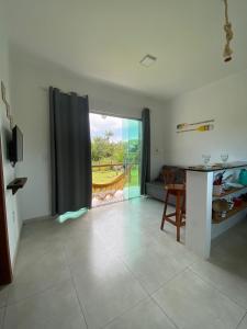 a living room with a table and a large window at Villa Ohana - Flats in Taipu